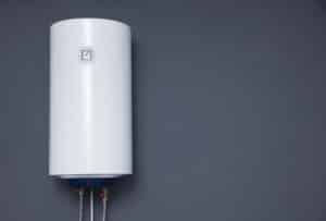 modern electric boiler on a gray plain wall. white water heater. space for text